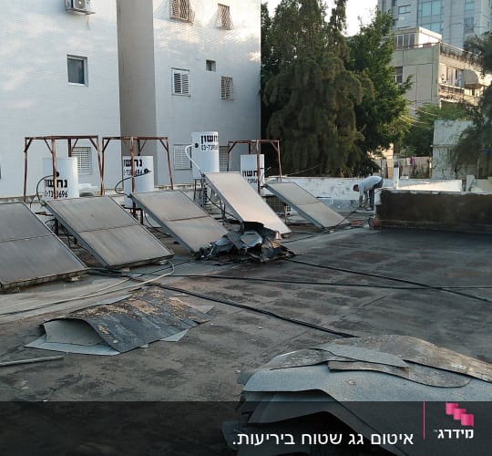 אדם מבצע איטום גג עם יריעות ביטומניות.